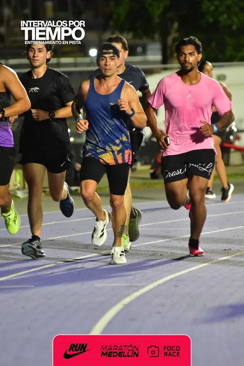 Eros corriendo con un grupo durante un entrenamiento de intervalos en la pista de Medellín